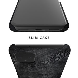 Puede incluir: Una funda de tel&eacute;fono negra con un patr&oacute;n de veta de madera. La funda tiene una protuberancia de c&aacute;mara elevada y un recorte para el puerto de carga del tel&eacute;fono.