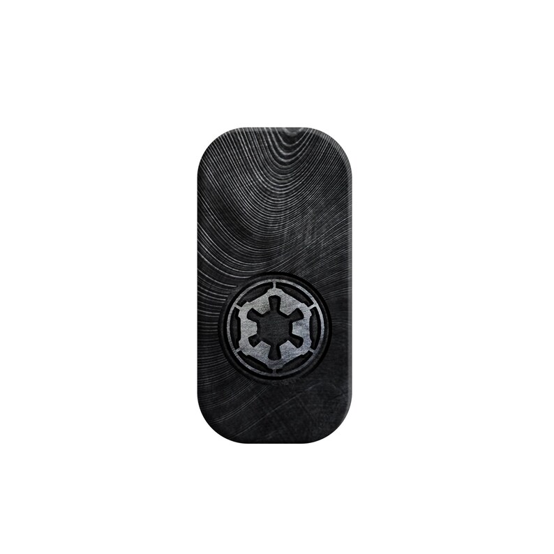 K&ouml;nnte beinhalten: Ein rechteckiges Schild aus schwarzem Holz mit einem silbernen imperialen Symbol aus Star Wars.