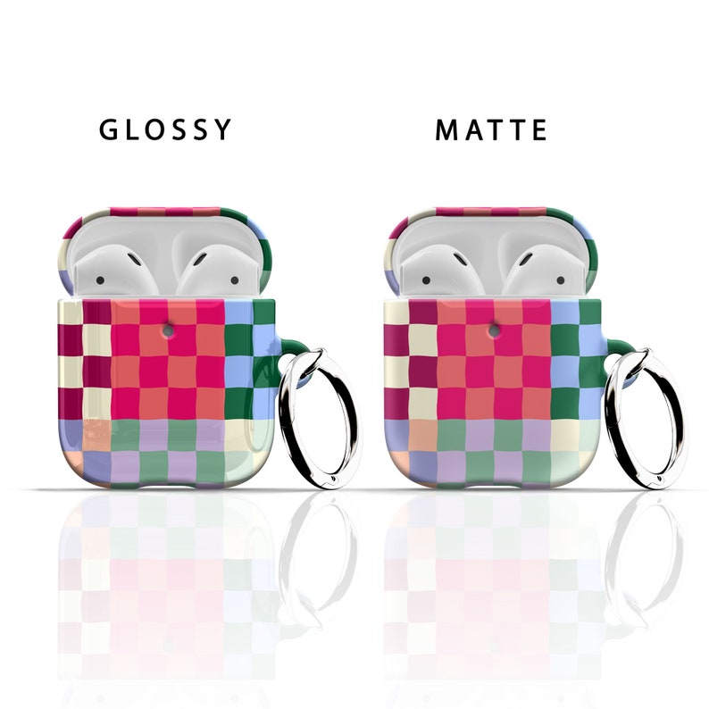 Puede incluir: Dos estuches para Airpods con un patr&oacute;n a cuadros en tonos de rosa, rojo, verde, azul y blanco. El estuche de la izquierda es brillante y el estuche de la derecha es mate. Ambos estuches tienen un peque&ntilde;o anillo met&aacute;lico adjunto.