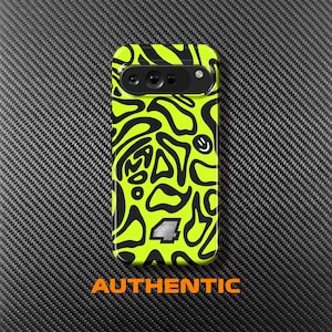 Puede incluir: Una funda de teléfono verde neón con un patrón abstracto negro, una carita sonriente y el número 4. La palabra "AUTHENTIC" está impresa en naranja en la parte inferior. La funda está sobre una superficie negra texturizada.