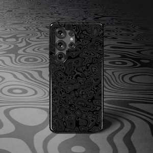 Puede incluir: Una funda negra para smartphone con un patrón abstracto y ondulado. La funda tiene un acabado brillante y presenta una matriz de cámaras de lentes múltiples. El fondo tiene un patrón similar en tonos grises.