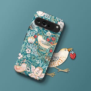 May include: A teal phone case with a floral pattern featuring birds and strawberries. The case has a cutout for the camera lens.