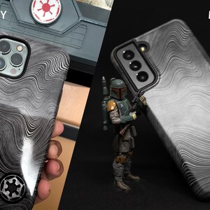May include: Two phone cases with a black and white wavy pattern. The case on the left is glossy and the case on the right is matte. Both cases have a black and white symbol in the lower right corner.