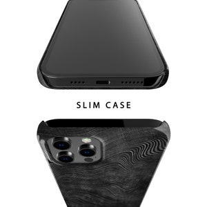 May include: A black phone case with a wood grain pattern. The case is designed to fit a phone with a triple camera system. The case is slim and has a smooth finish.