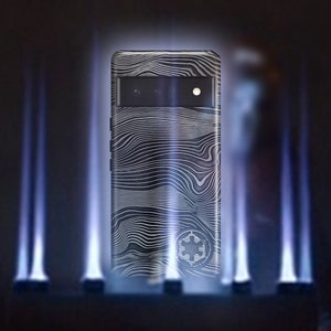 May include: A black smartphone case with a white and gray wavy pattern and a black and white symbol. The case has a black camera lens with three holes.