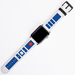 May include: A white Apple Watch with a blue and white patterned band. The band features a red circle and a series of blue rectangles.