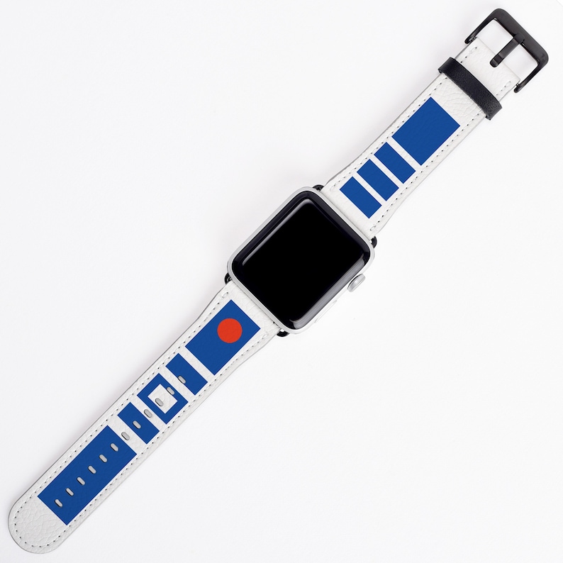 May include: A white Apple Watch with a blue and white patterned band. The band features a red circle and a series of blue rectangles.