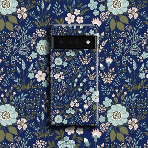 Puede incluir: Una funda de teléfono azul con un patrón floral. La funda tiene un recorte para la lente de la cámara.