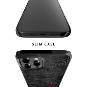 May include: Black phone case with a wood grain pattern and a camera lens cutout. The case is designed to be slim and protective.