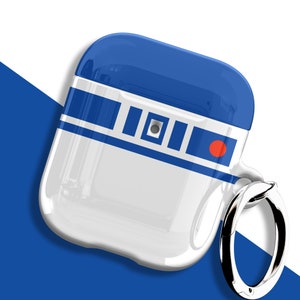 以下が含まれることがあります： R2-D2のデザインが施された白と青のAirPodsケース。ケースの上部は青、下部は白で、青いストライプと赤い円があります。ケースには銀色のリングが付いています。