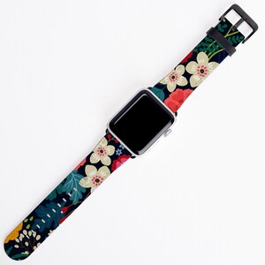 Op de afbeelding: Een zwart horlogebandje met een bloemenpatroon met witte, rode, roze en groene bloemen. Het bandje is compatibel met Apple Watches.