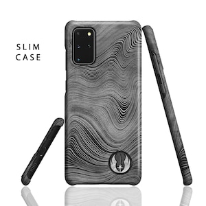 Puede incluir: Una funda de tel&eacute;fono negra con un patr&oacute;n ondulado gris y blanco y un s&iacute;mbolo de la Alianza Rebelde. La funda est&aacute; etiquetada como "SLIM CASE".