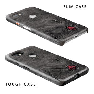 May include: Two phone cases, a slim case and a tough case, are displayed. Both cases have a swirling, wood-grain pattern in shades of gray and black. The slim case is labeled "SLIM CASE" and the tough case is labeled "TOUGH CASE". Each case has a red emblem.