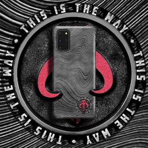 Könnte beinhalten: Eine schwarze Handyhülle mit einem wellenförmigen Muster und einem Mandalorianer-Symbol. Die Hülle trägt den Text "This is the way" am Rand.
