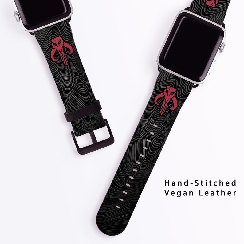 May include: Two black and white patterned Apple Watch bands with a red Mandalorian symbol. The bands are made of vegan leather and are hand-stitched. "Hand-Stitched Vegan Leather" is written in white text on a white background.