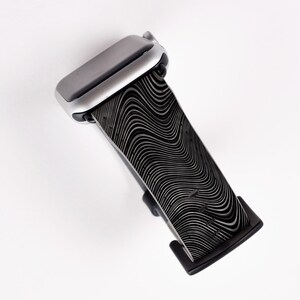 May include: A black and silver Apple Watch band with a wavy, abstract pattern.