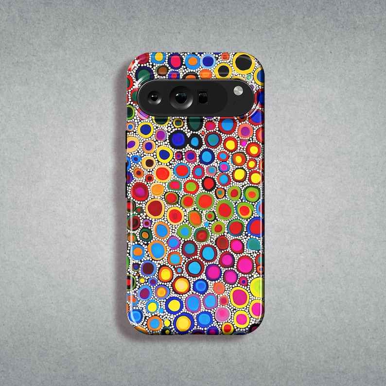 K&ouml;nnte beinhalten: Eine farbenfrohe Handyh&uuml;lle mit einem Muster aus kleinen Kreisen in verschiedenen Farben, darunter Rot, Gelb, Blau, Gr&uuml;n und Pink. Die H&uuml;lle ist f&uuml;r ein Smartphone mit einer Kamerabuckel konzipiert.