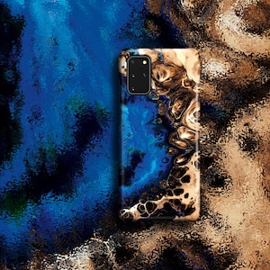 May include: A phone case featuring an abstract design in shades of blue, black and gold. The case has a camera cutout in the top left corner.