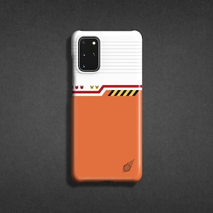 May include: A white and orange phone case with a black camera lens and a black and white graphic of a comet. The case has a white stripe with black and yellow stripes.
