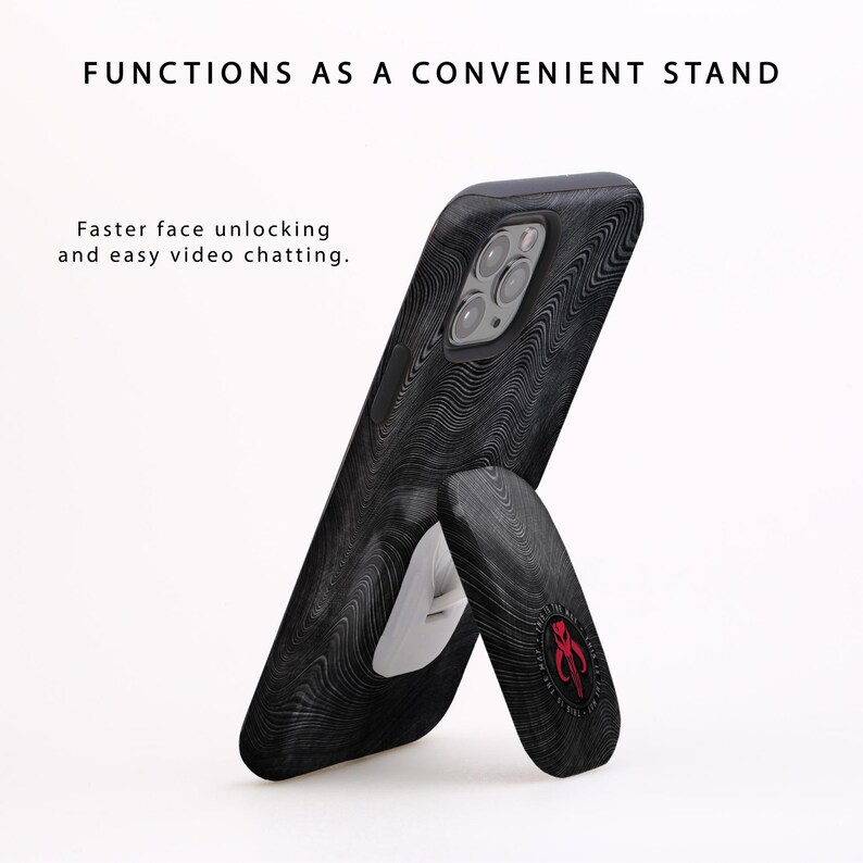 May include: A black phone case with a wood grain pattern and a kickstand. The kickstand is in the up position, allowing the phone to stand upright. The case has a red and white logo on the back.
