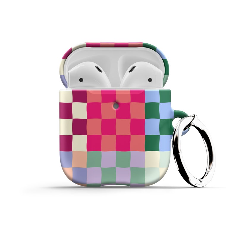 Puede incluir: Una funda para Airpods con un patr&oacute;n de cuadros coloridos y un llavero plateado. La funda est&aacute; abierta, revelando los Airpods blancos en el interior.