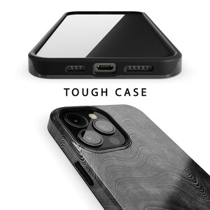 May include: A black phone case with a white wood grain pattern. The case has a raised camera bump and a cutout for the phone's charging port. The text "TOUGH CASE" is printed on the case.