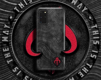 May include: Black phone case with a textured design and a Mandalorian symbol. The case has the text "This is the way" repeated around the edge.