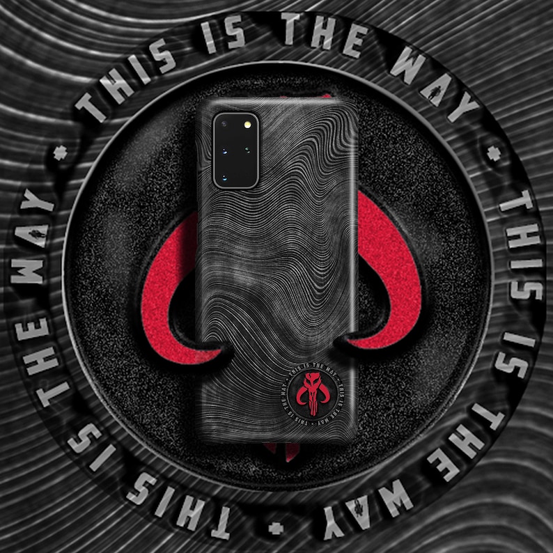 May include: Black phone case with a textured design and a Mandalorian symbol. The case has the text "This is the way" repeated around the edge.