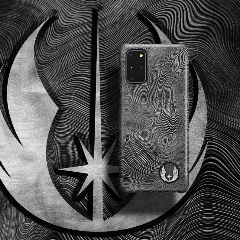 Puede incluir: Una funda de tel&eacute;fono negra y blanca con un patr&oacute;n ondulado y un s&iacute;mbolo de la Alianza Rebelde. La funda est&aacute; dise&ntilde;ada para un tel&eacute;fono Samsung Galaxy.