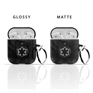 May include: Two black AirPod cases with a white Imperial symbol and a silver key chain. One case is glossy and the other is matte.