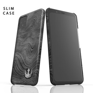 Puede incluir: Una funda de tel&eacute;fono negra con un s&iacute;mbolo blanco de la Alianza Rebelde y un patr&oacute;n ondulado abstracto. La funda est&aacute; dise&ntilde;ada para adaptarse a un tel&eacute;fono delgado. La funda se muestra junto a un tel&eacute;fono negro con una pantalla.