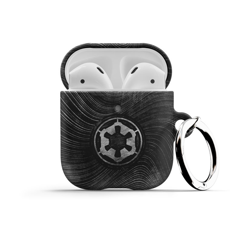 May include: Black and white Airpods case with a Star Wars Imperial logo and a silver key ring. The case is open and the white Airpods are visible inside.