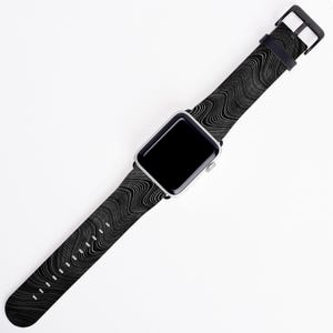 May include: A black and white patterned Apple Watch band with a silver watch face.
