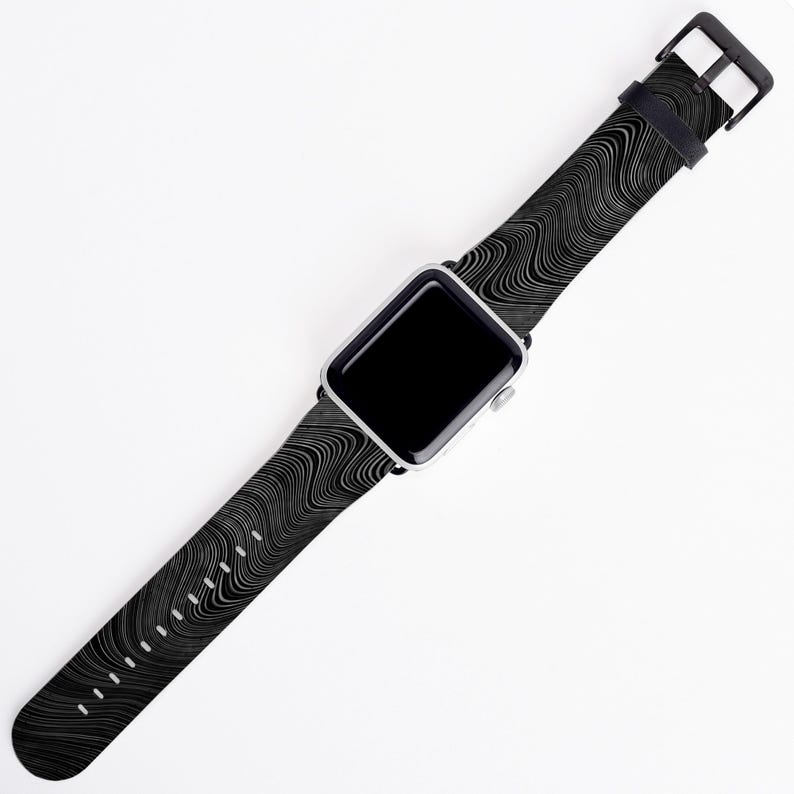 May include: A black and white patterned Apple Watch band with a silver watch face.