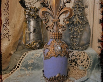 Baroque style decoration flask with gold lily flowers and vintage crystal rhinestones on cracked lavender color background