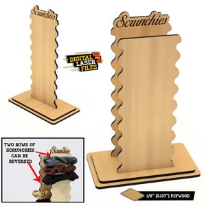 Op de afbeelding: Een houten scrunchiehouder met twee rijen gleuven om haarbandjes op te bergen. De houder is gemaakt van 1/8 inch multiplex en heeft een gegolfde rand. De houder is bovenaan met "Scrunchies" gelabeld.