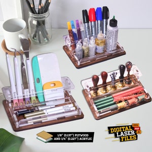 May include: Three clear acrylic organisers with wooden bases. The organisers are filled with various craft supplies, including pens, markers, stamps, and tools. The organisers are made from 1/8 inch plywood and 1/4 inch acrylic. The text "DIGITAL LASER FILES" is printed on the bottom of the image.