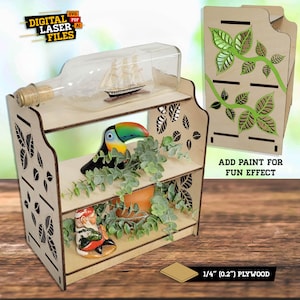 May include: Two-tiered wooden shelf with a leafy design, featuring a glass bottle with a ship inside, a toucan figurine, a small gnome figurine, and a potted plant. The shelf is made of 1/4 inch plywood and can be painted for a fun effect.