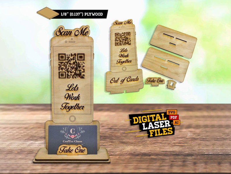 Op de afbeelding: Een houten telefoonstandaard van 1/8 inch multiplex, met een QR-code en de tekst "Scan Me" en "Let's Work Together". De standaard is ontworpen om visitekaartjes te houden en heeft een "Take One" bord.