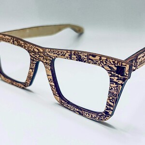 Puede incluir: Un par de gafas de madera marr&oacute;n con un patr&oacute;n de c&oacute;mic. Las gafas tienen una forma cuadrada y lentes transparentes.