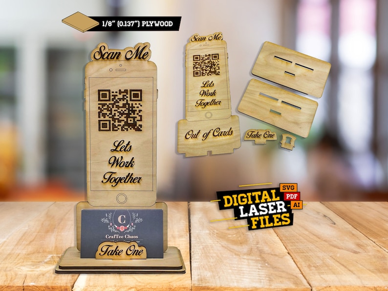 Op de afbeelding: Een houten telefoonstandaard van 1/8 inch multiplex, met een QR-code en de tekst "Scan Me" en "Let's Work Together". De standaard is ontworpen om visitekaartjes te houden en heeft een "Take One" bord.