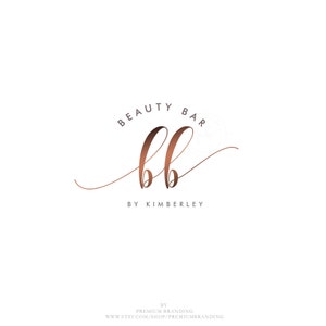 May include: A logo design for a beauty bar, featuring the words "BEAUTY BAR" in a serif font above the stylized letters "bb" in a copper color. Below the letters is the text "BY KIMBERLEY". The background is white.