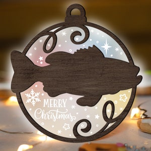 May include: A wooden Christmas ornament shaped like a fish with a white background and the text "Merry Christmas".