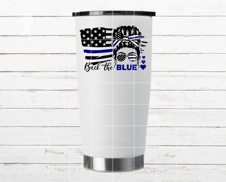 Puede incluir: Un vaso blanco con un dise&ntilde;o de bandera estadounidense azul y blanca, una cara de mujer con un mo&ntilde;o y gafas de sol, y el texto "Back the BLUE" con corazones.