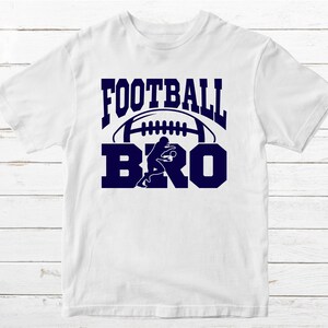 May include: White t-shirt with a navy blue graphic that says "FOOTBALL BRO" with a football and a football player silhouette.