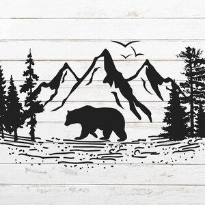 May include: Black silhouette of a bear walking in front of a mountain range with trees on either side.