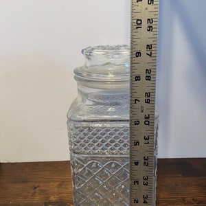 Op de afbeelding: Een glazen pot met een diamantpatroon en een deksel. De pot is ongeveer 33 cm hoog.