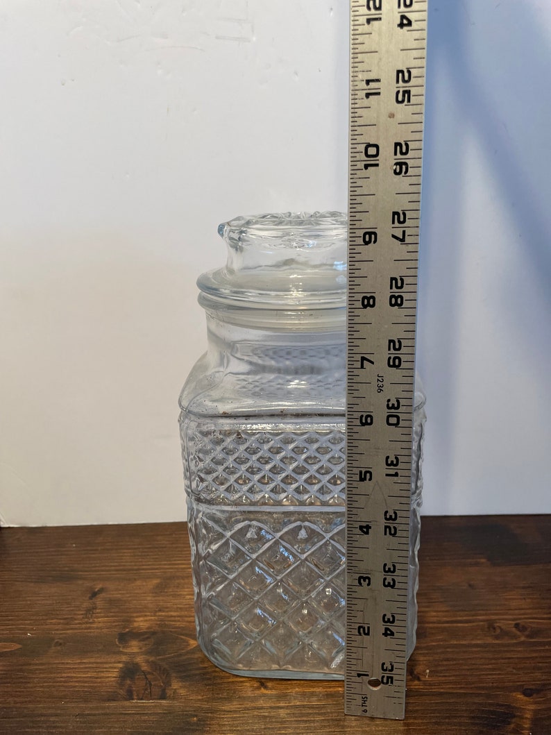 Op de afbeelding: Een glazen pot met een diamantpatroon en een deksel. De pot is ongeveer 33 cm hoog.