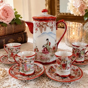 May include: A porcelain tea set featuring a tall teapot with a lid and four matching cups and saucers. The white ceramic pieces are decorated with colorful hand-painted scenes of figures in traditional attire, floral motifs, and red trim accents.