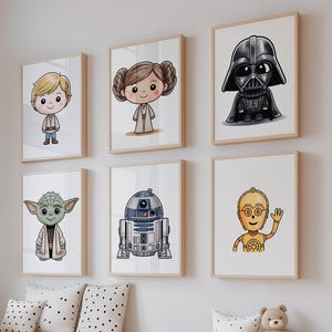 Pode incluir: Uma coleção de impressões de arte emolduradas de personagens de Star Wars. As impressões apresentam ilustrações de desenhos animados de Darth Vader, Yoda, R2-D2, C-3PO e outros personagens. A obra de arte é exibida no quarto de uma criança com um urso de pelúcia e caixas de armazenamento.